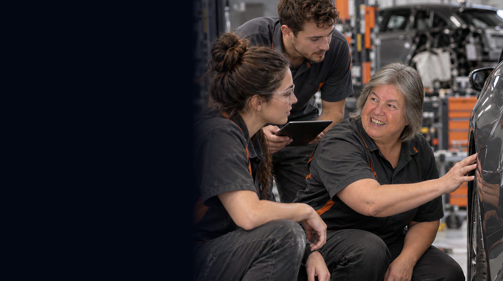 Sharon Ashley with two technicians beside a vehicle in a collision repair shop